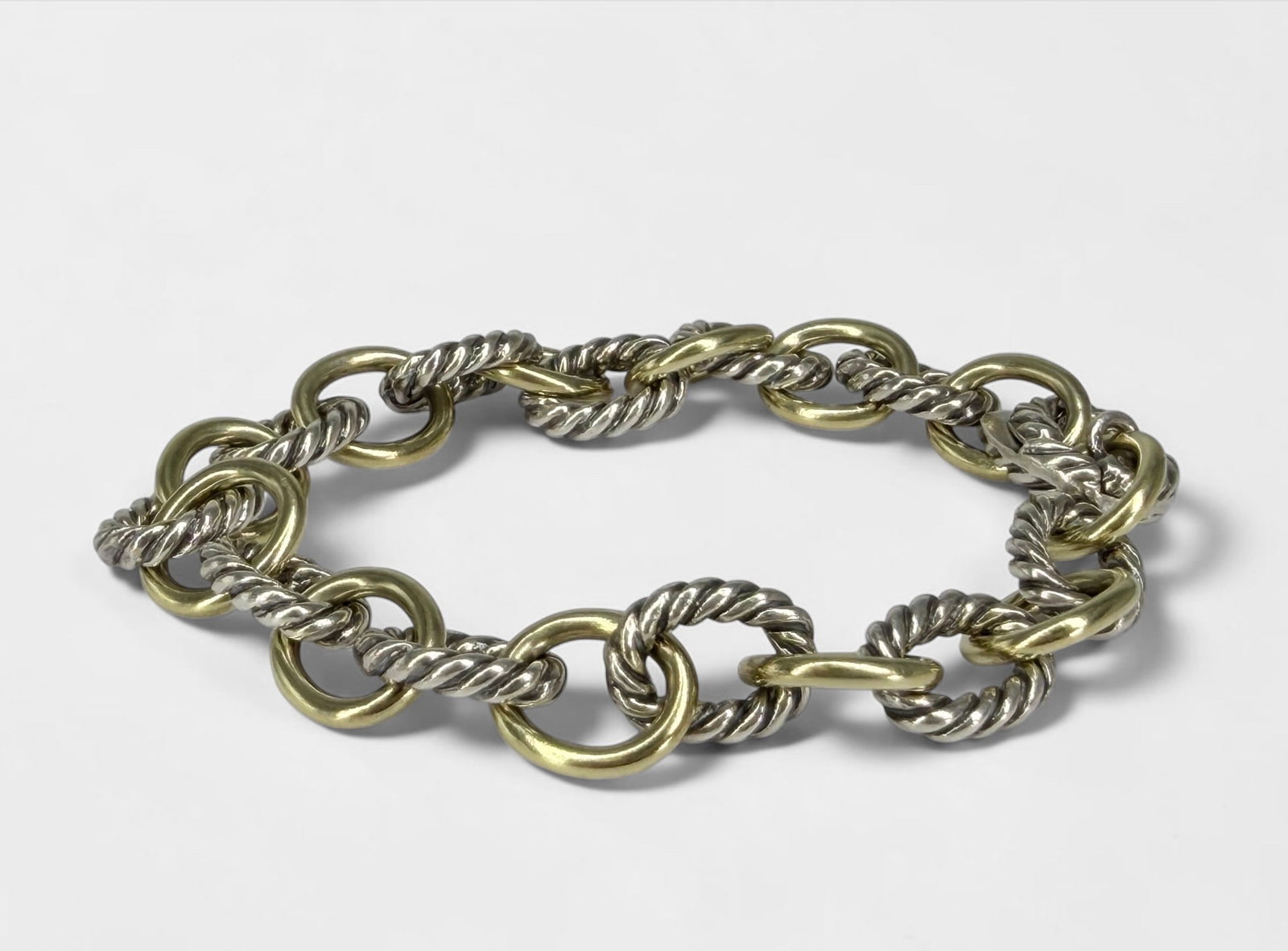 David Yurman 18K Yellow Gold & Sterling Link Bracelet: Weight: 27.89g Length: 7 1/2" Long Dimensions: 10mm links Condition: Tarnishing to the sterling chains, otherwise in good condition. Missing David Yurman charm.