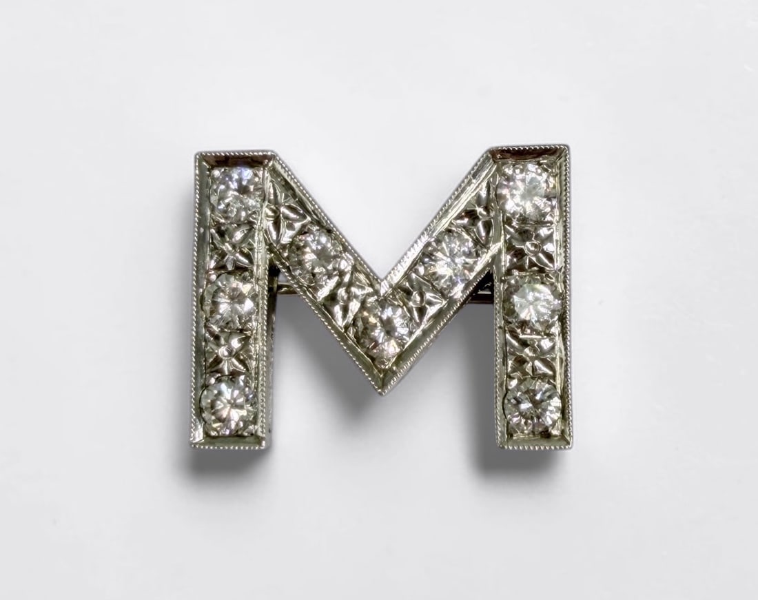 14K White Gold & Diamond 'M' Brooch: Total Weight: 4.75g Dimensions: 1/2" x 3/4" Condition: The brooch is in good condition. 