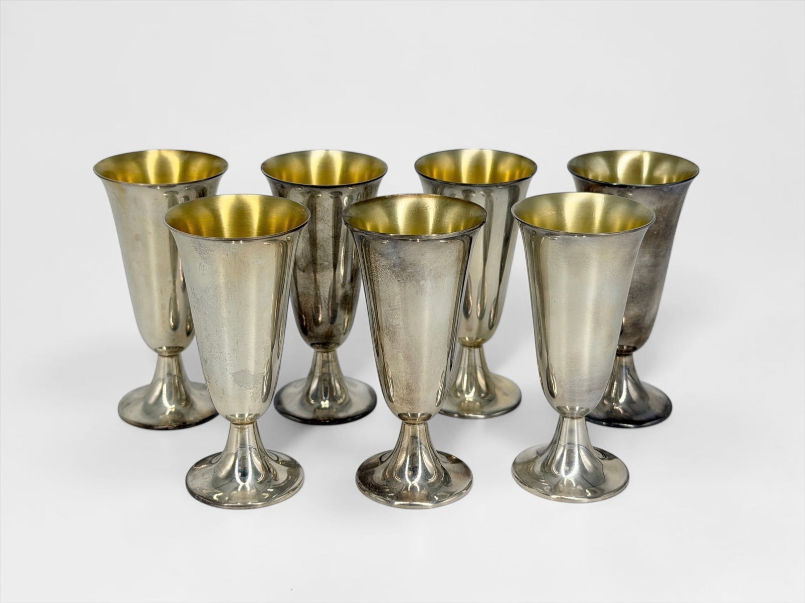 (7) Tiffany & Co Sterling Silver Cordials: With a blue Tiffany felt bag and six pouches Height: 2 7/8" T Total Weight: 7.1 ozt Condition: Good with some tarnishing consistent with sterling