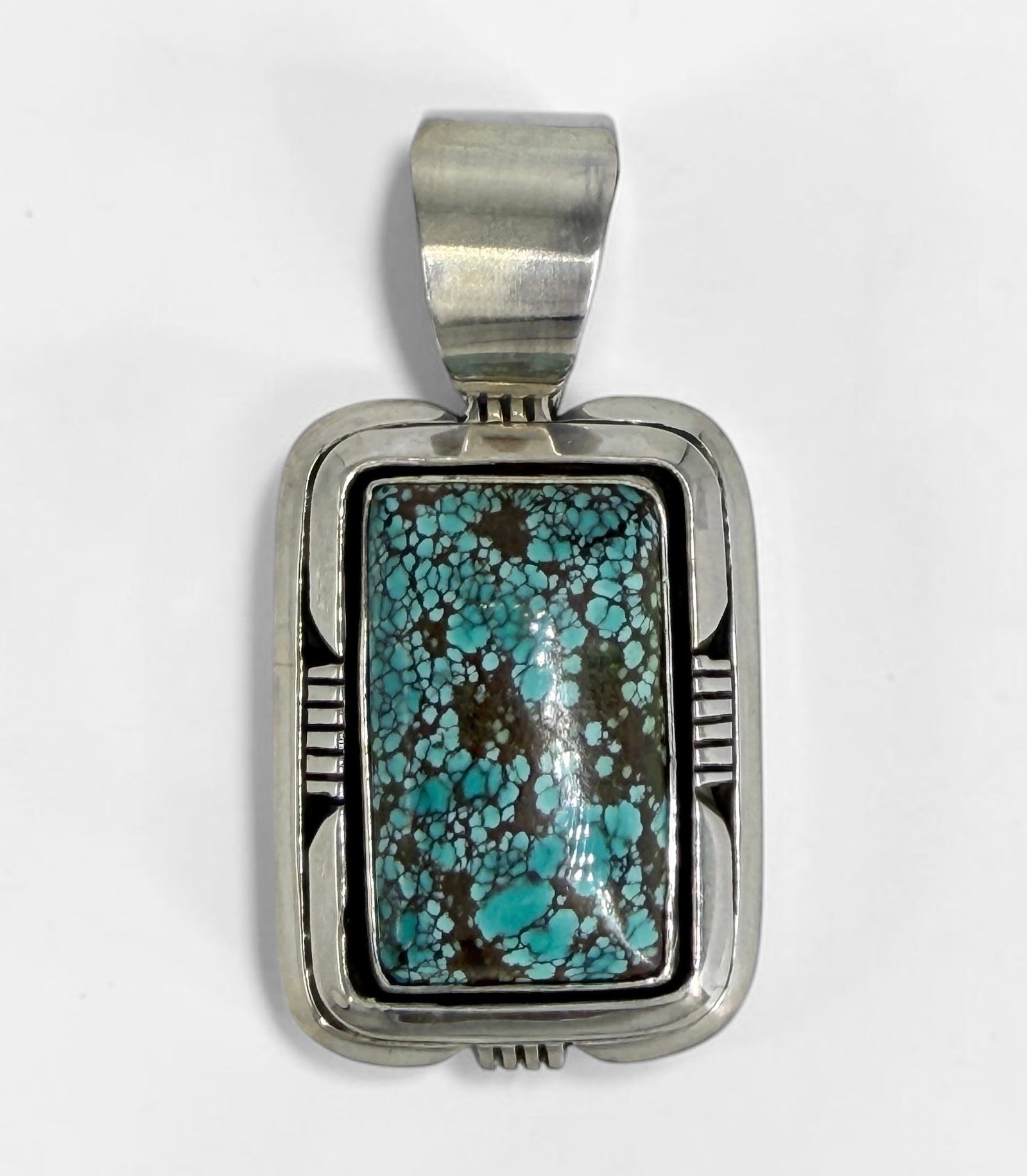 Etta Endito Turquoise & Sterling Navajo Pendant: Stamped on the reverse. Dimensions: 2" x 1" Condition: The pendant is in very good condition. 