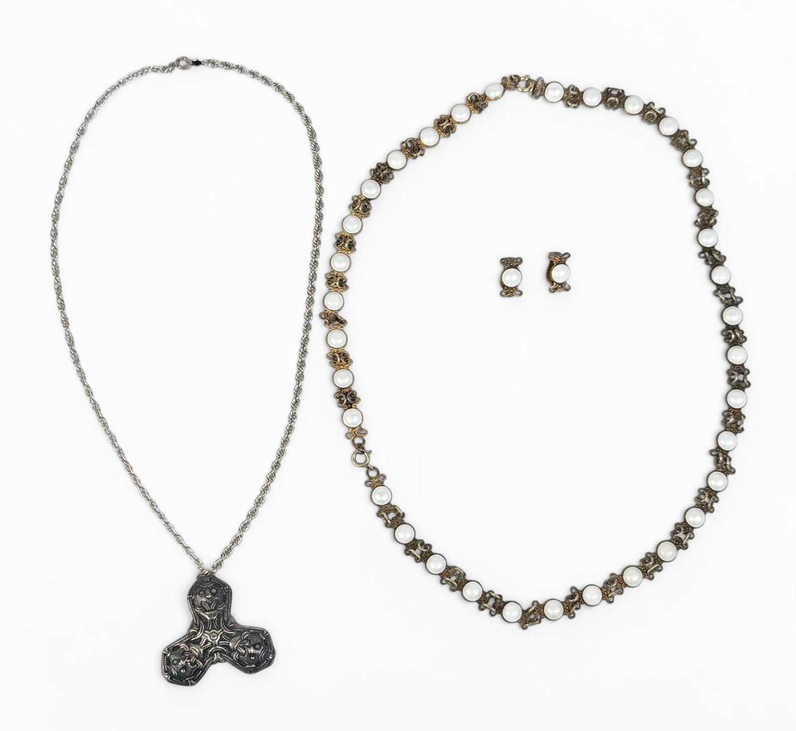 (3) Norwegian Sterling Jewelry Pieces: The lot includes two necklaces and one pair of clip-on earrings. Length of Longer Necklace: 23" Long Total Weight: 50.8g Condition: Tarnishing throughout the jewelry at