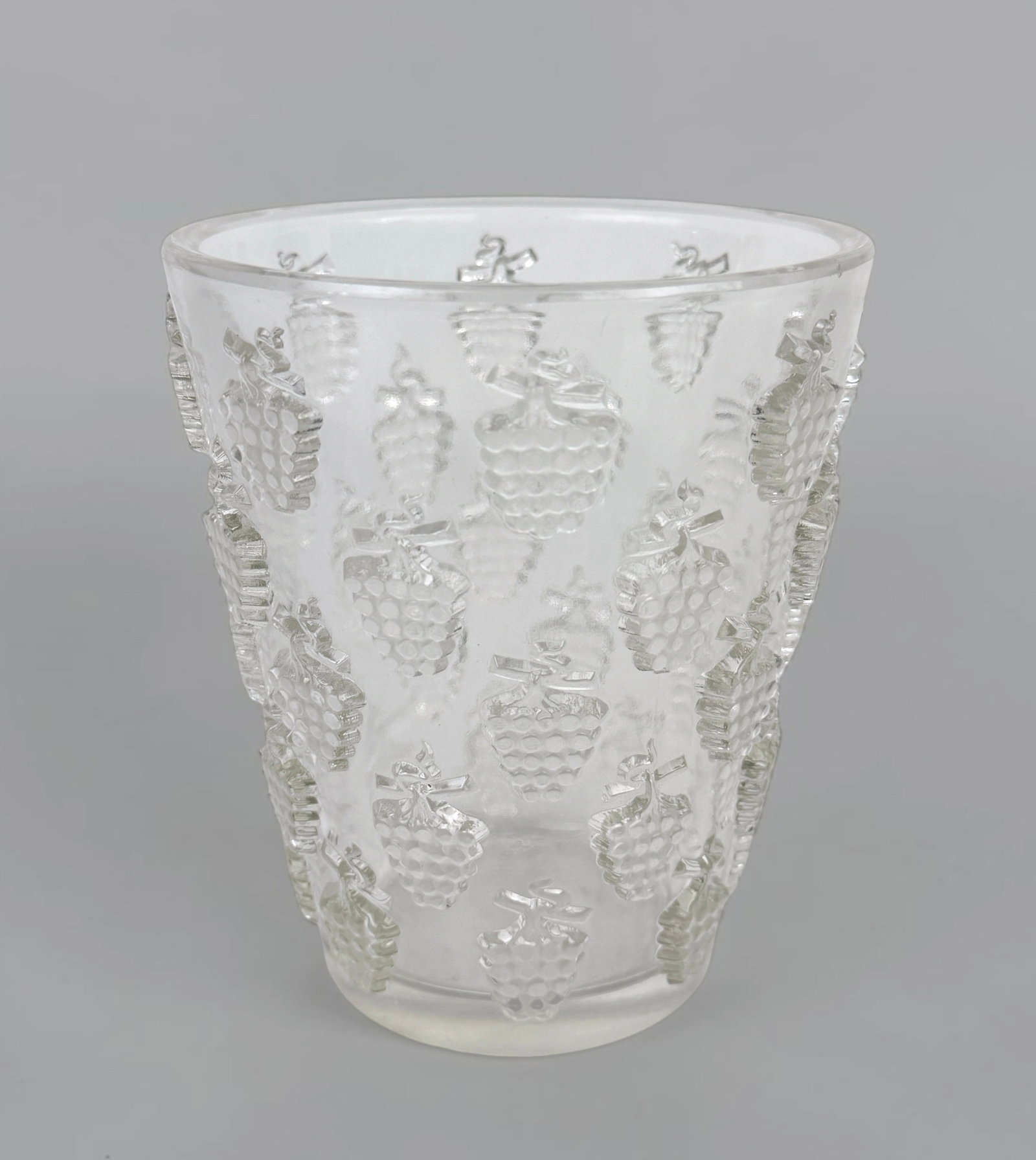 R. Lalique "Malaga" Glass Vase: Inscribed R. Lalique on the bottom of the vase. Dimensions: 5 1/2" Tall x 5" Diameter Condition: The glass is in good condition. The bottom is scratched throughout.