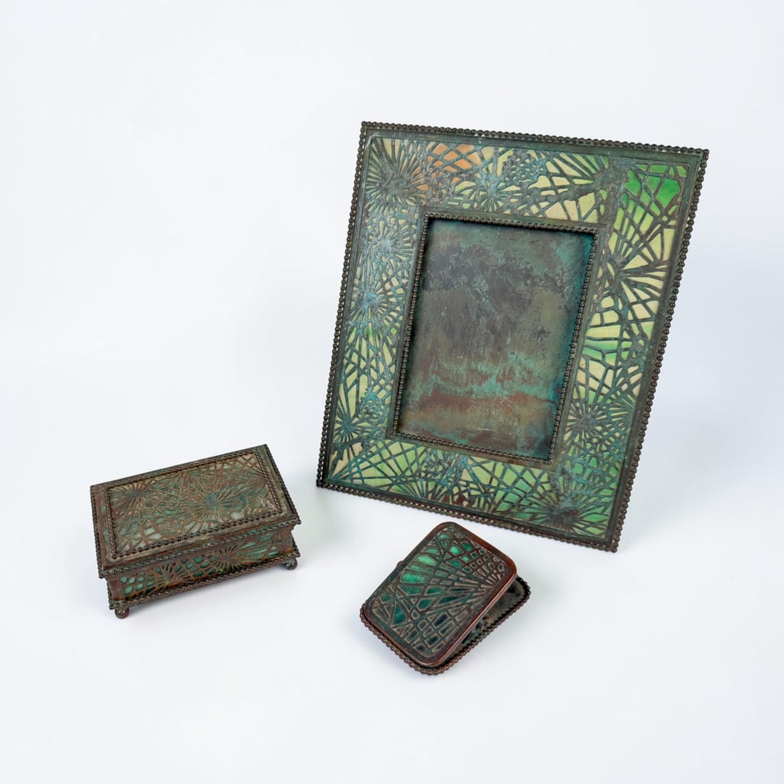 (3pc) Tiffany Studios Pine Needle Desk Set: The lot includes a picture frame, letter clip, and a utility box. The frame can fit a 4" x 6" image. Dimensions of picture frame: 8" Wide x 9 1/2" Tall x 5
