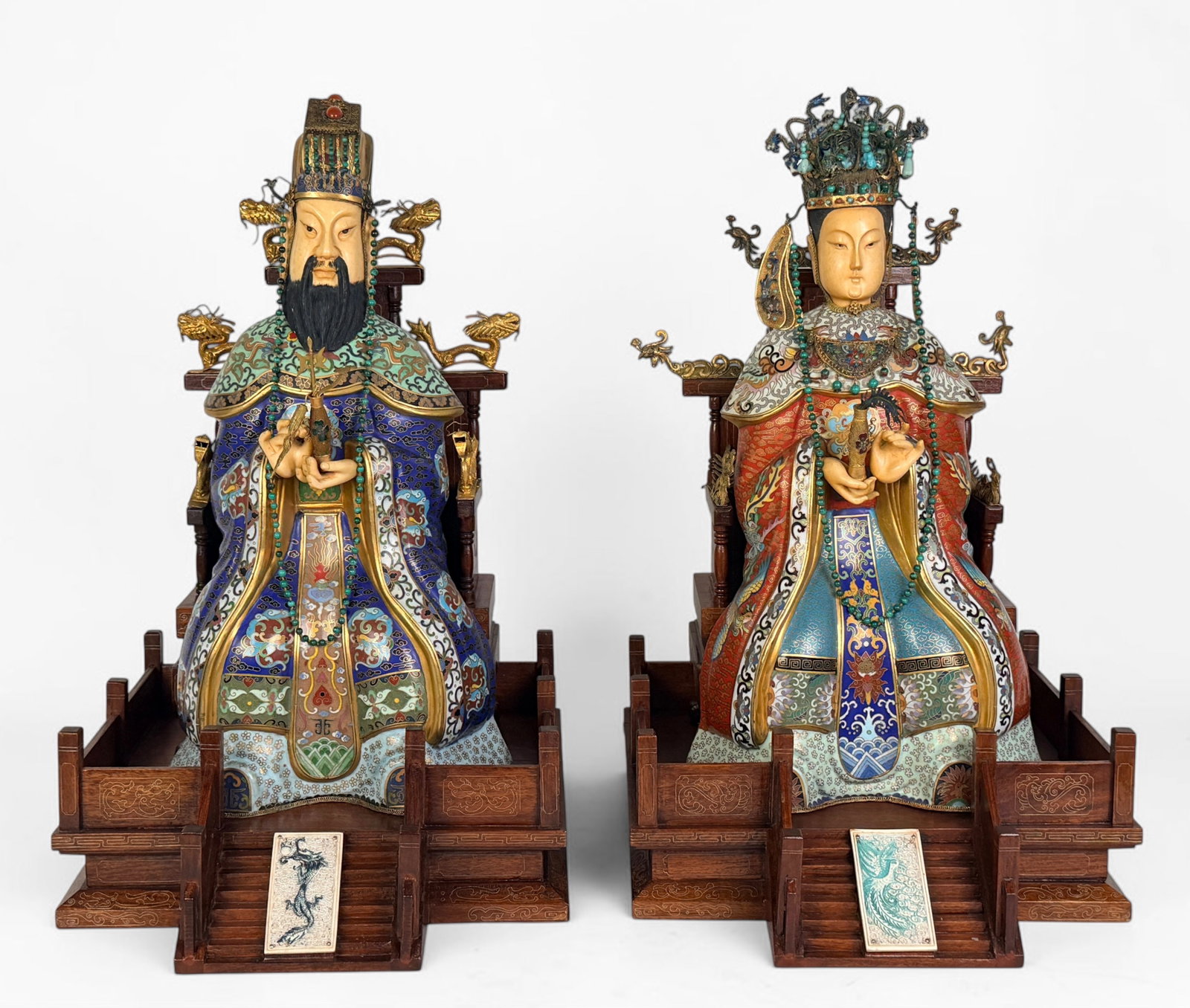 Pair of Chinese Cloisonne Bone Emperor & Empress Figures: The figures are carved bone with cloisonne clothing and inlaid metalwork and semiprecious stones, including malachite and turquoise. The throne is carved wood with metal filigree elements. 