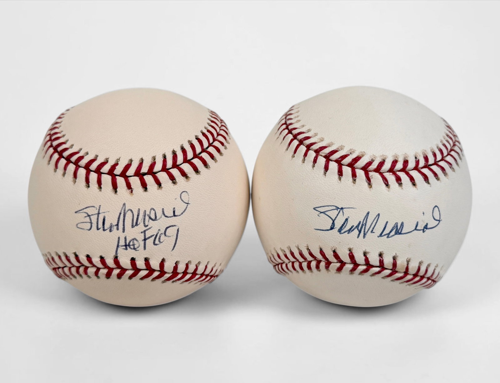 (2) Signed Stan "The Man" Musial Official Major League Baseballs: One ball is signed as a Hall of Fame ball. Both come in display cases. Size: Approx. 3" Diameter Condition: The balls are in overall very good condition, with some signs of aging.