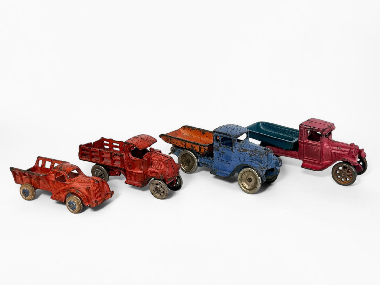 (4) Antique Cast Iron Trucks (G): Includes brands Kilgore, Arcade, and more. Dimensions of Largest: 2 1/2" x 6" x 2" Condition: One car has a broken wheel that has been repaired. Rust and loss 