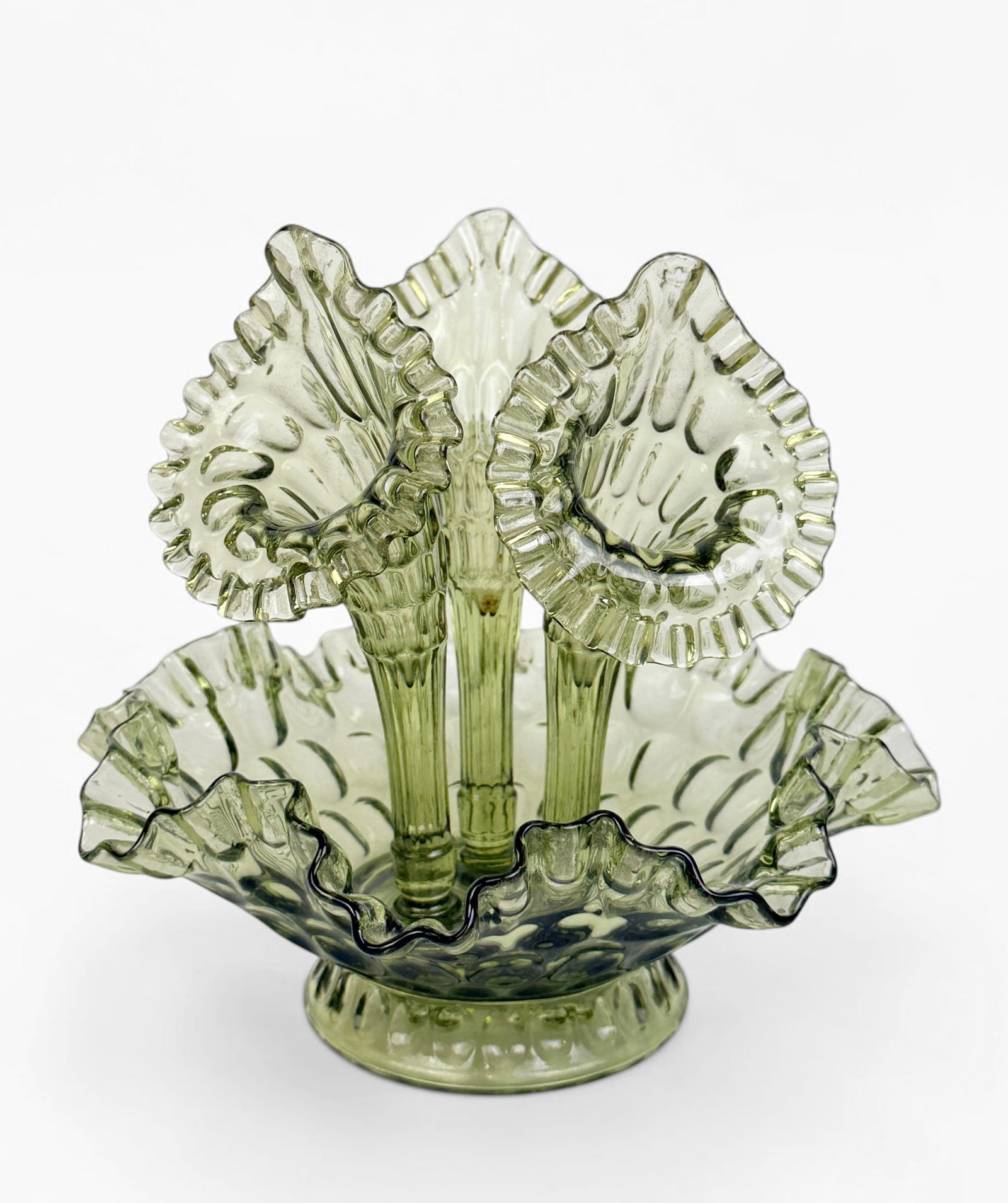 Fenton Colonial Green Thumbprint 3-Horn Epergne: This item was produced between 1964 and 1968. Each of the horns comes out. Dimensions: 9 1/2" Tall x 10" Diameter Condition: The epergne is in good condition.