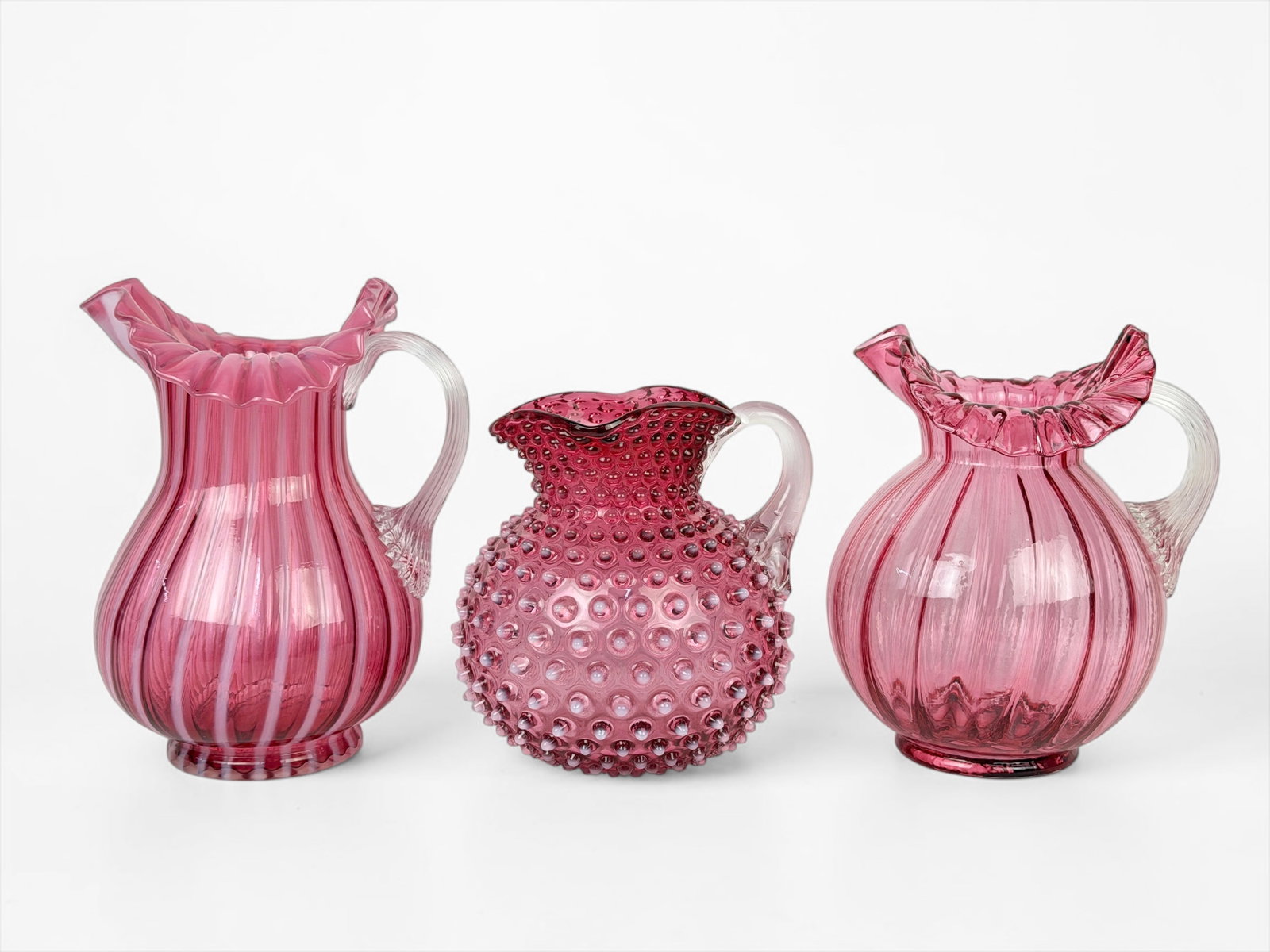 (3) Pink Fenton Glass Pitchers: Largest: 11" Tall x 7 1/2" Wide Condition: The pitchers are in good condition. Please see images for details. 