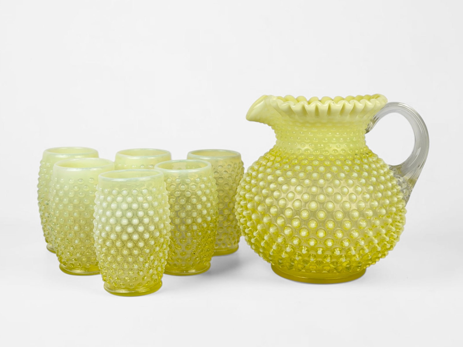 (7pcs) Uranium Glass Fenton Pitcher and Glass Set (B): Set includes (1) pitcher, (3) tall cups, and (3) short cups. Pitcher: 8" Tall x 8" Widest Point Tall Cup: 5" Tall x 3" Wide Condition: The set is in good 