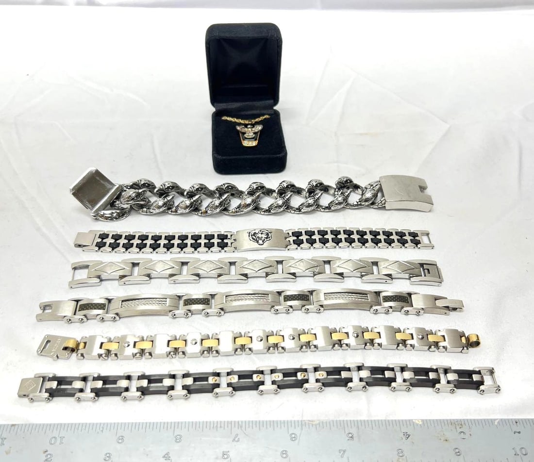 Six Mens Bracelets and Eagle Necklace: Six Mens Bracelets and Eagle Necklace. Necklace has an approximately 24 inch long chain, 14 GEP. All men's bracelets are size 8 1/2, all stainless steel, one Chicago Bears, one Invicta, one eagle