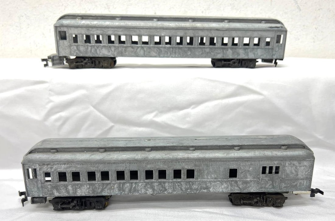HO Gauge die-cast passenger coach and combination: HO Gauge die-cast passenger coach and combination car (baggage/mail and ?). Coach chassis/frame has relaxed and is curved. Trains have never been painted/decorated. Unsprung die-cast truck assemblies