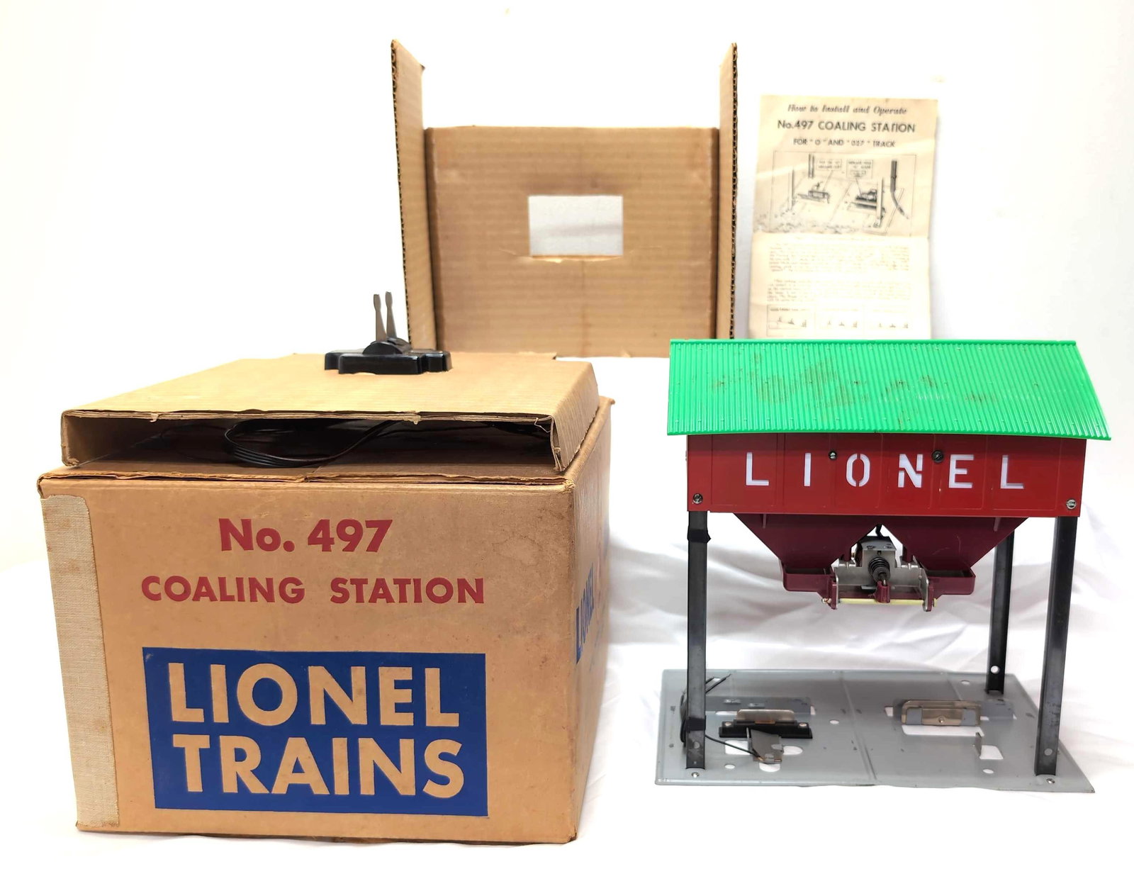 Postwar Lionel 497 Coaling Station in original box: Postwar Lionel O Gauge 497 Coaling Station in original box with inserts, instructions sheet and controller. Station looks C6+. Box has some older tape removal, old price/inventory stickers. Box is