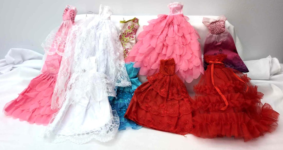 Ten Barbie sized gowns dresses hat more one marked: Ten Barbie sized gowns and/or dresses, hat, tiara and attached train, one red gown/dress is marked with a Barbie/Mattel sewn in tag. Dresses have been on and off dolls, clean, some marks on some dress
