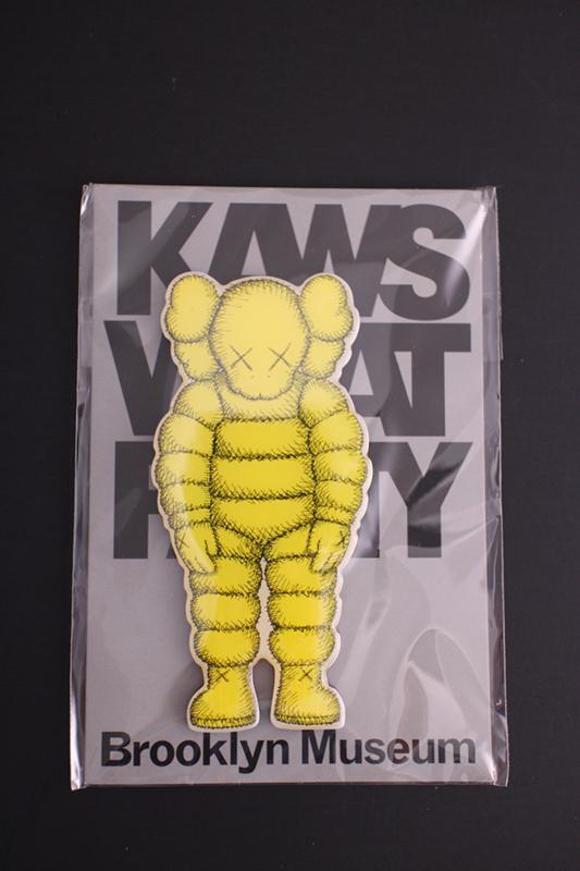 KAWS (American, b.1974) "What Party?" yellow magnet, brand new, 4 x 2 in. (1 of 2)