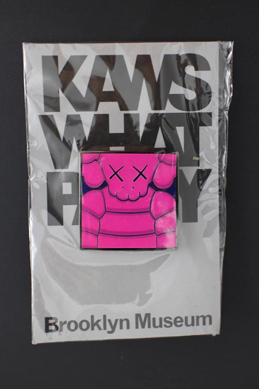 KAWS (American, b.1974) "What Party?" bright pink and blue pin, never opened 1 1/2 x 1 1/2 in. (1 of 3)