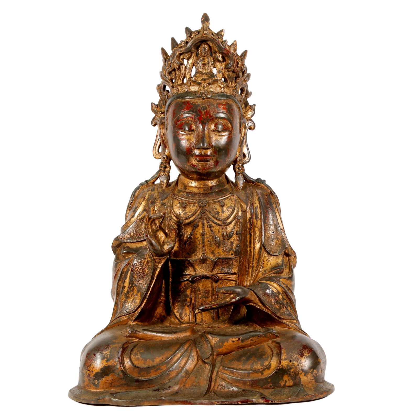 A Gilt Bronze Figure Of Avalokitesvara: A Gilt Bronze Figure Of Avalokitesvara. The seated figure with a composed countenance rendered clad in a long flowing robes subtly picked out in relief, the voluminous drapery elegantly cascading in f
