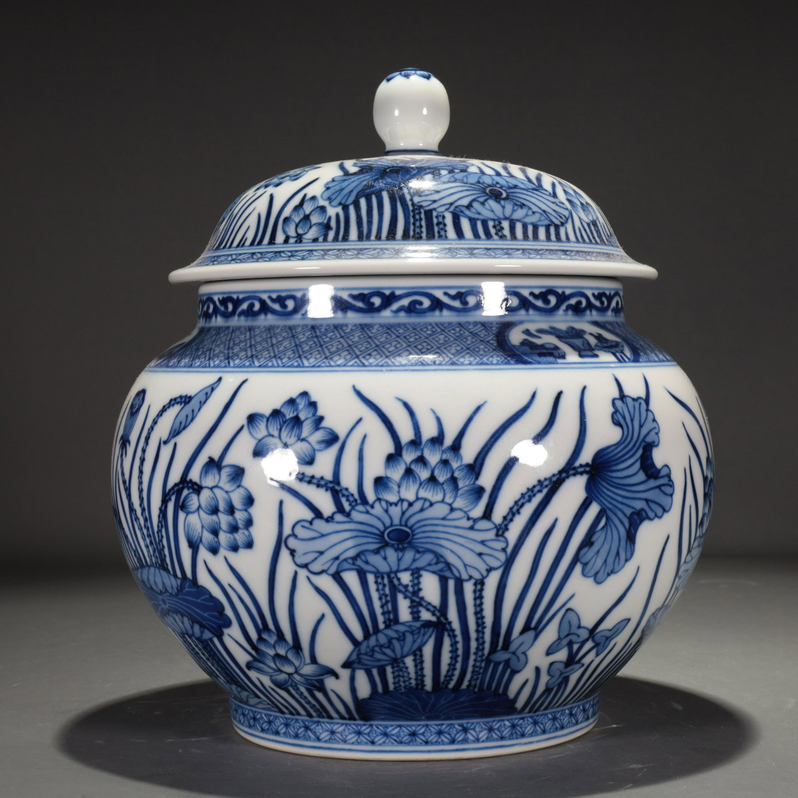 A Blue And White Jar And A Lotus Leaf-Form Cover: A Blue And White Jar And A Lotus Leaf-Form Cover. The neck is painted in deep cobalt blue with a section of latticework, the bottom with a band of quatrefoil patterns. Chinese Qing Dynasty. Qianlong S