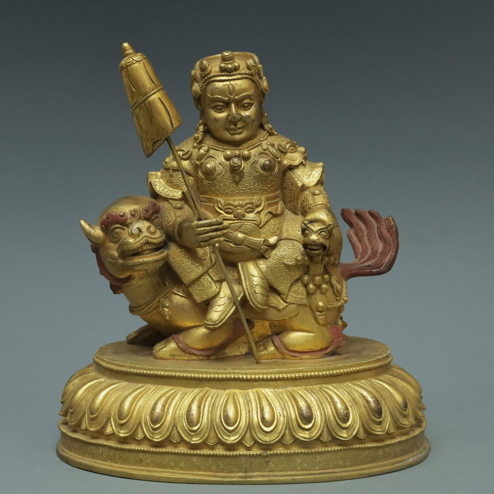A Magnificent Gilt-Bronze Figure Of Lokapala: A Magnificent Gilt-Bronze Figure Of Lokapala. The figure with a dignified expression is seated on a mythical beast and rendered clad in an armor. 17th Century. Size:21.6cmx16cmx24cm