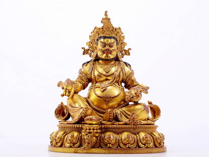 A solemn gilt bronze statue of the God of Wealth: A majestic gilt bronze statue of the God of Wealth, Ming Dynasty, China, a stunning piece of Buddhist art. The face of the Buddha statue is solemn and kind, and its eyes are deep, symbolizing wealth