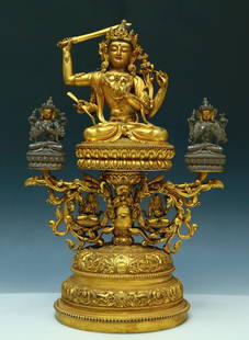 A Brilliant Gilt-Bronze Figure Of Four-Armed Manjusri: A Brilliant Gilt-Bronze Figure Of Four-Armed Manjusri. Seated on a base with a peaceful expression, body adorned with jewelry ornaments, topknot surmounted by a splendid diadem, one hand brandishing