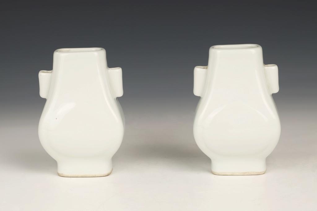 Pair of White-Glazed Hu-Shaped Twin-Handled Vases. 20th Century: China, 20th century Dimensions: 4.3" (10.8cm) H (2) A pair of white-glazed handled vases shaped after the archaistic hu vessel. (2pcs) PLEASE NOTE THIS LOT IS TO BE OFFERED WITHOUT RESERVE. 20世