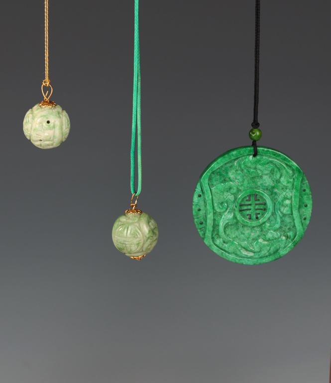 Pair of Jadeite Beads TOGETHER WITH Carved Jadeite Round Plaque: Dimensions: A:2" (5.4cm) Dia B: 0.9" (2.2cm) Dia (2) Comprising a pair of carved jadeite bead pendants and a jadeite round plaque decorated with bats and auspicious symbols. (3pcs) PLEASE NOTE THIS LO