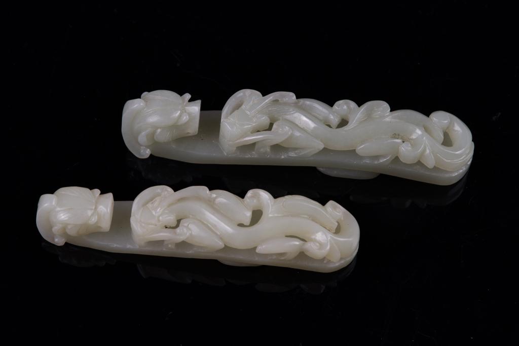 Pair of Celadon Jade Carved Dragon Belt Buckles: China Dimensions: 4" (10.2cm) L; 4 1/2" (11.4cm) L Pair of celadon jade carved dragon belt buckles. (2pcs) 青白玉雕龙带钩一对