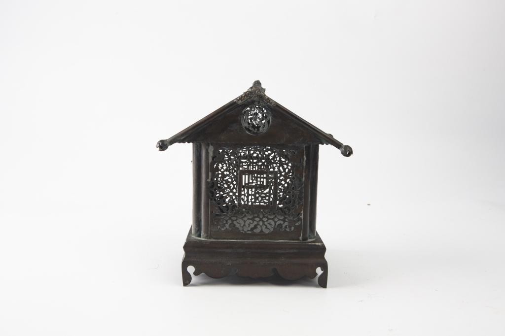 Pierced Brass Temple Form Cricket Cage, 19th Century: China, 19th century Dimensions: 7 1/4" (18.5cm) H Moulded into the shape of a temple, with openwork foliage decoration to the four sides, the roof decorated with butterfly and flowers. 19世ń