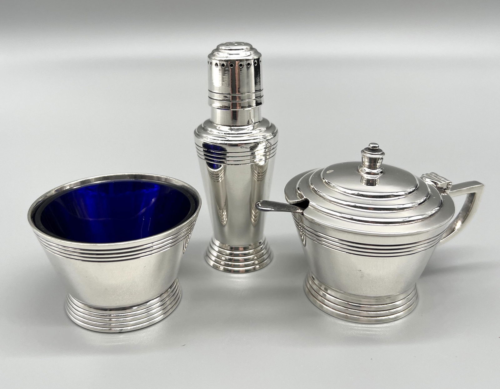 Art Deco Mappin & Webb Silverplate Cruet Set: Art Deco Mappin & Webb Silver-plate Cruet Set, designed by Keith Murray, 3pc set includes mustard pot with cobalt blue glass liner and spoon, salt cellar with glass liner, and pepper shaker, stamped "