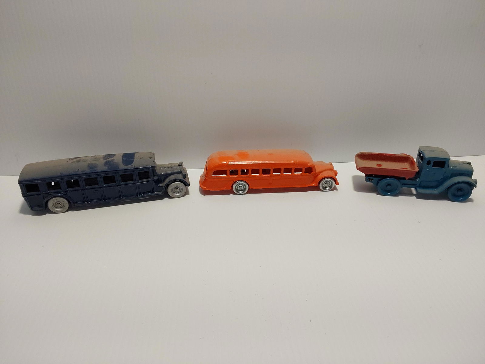 Arcade and Kilcore toy lot: cast iron Blue bus (Arcade) = 8" long Orange bus (Arcade) = 7" long Dump truck (Kilcore)= 6" long All repainted