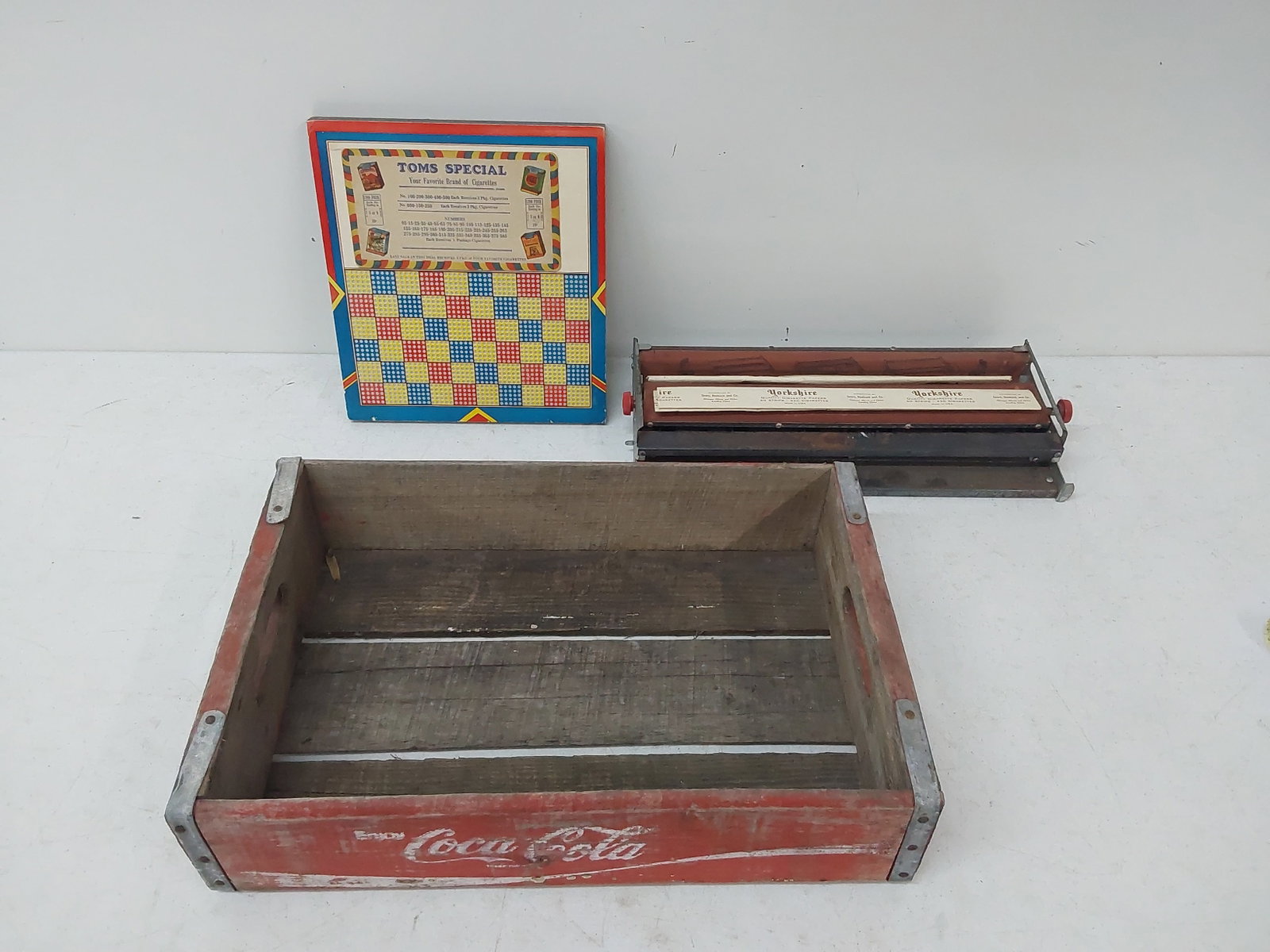 cigarette gameboard, tobacco roller and Coke crate: Tom's Special Cigarettes gameboard, Yorkshire tobacco roller and Coke crate