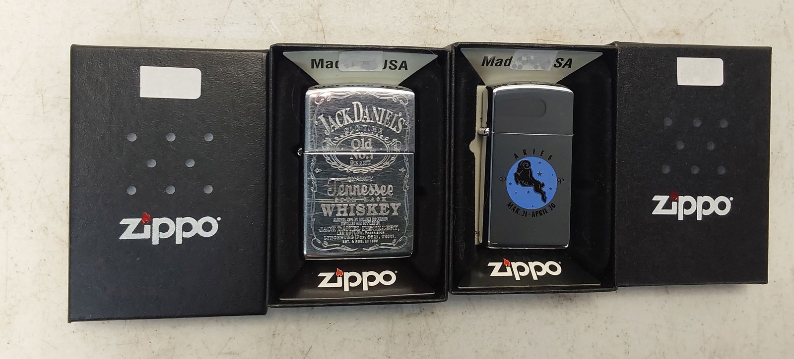 (2) collectible Zippo lighters: (1) 1994 Jack Daniels Tennessee Sour Mash Whiskey, high polish chrome Zippo lighter. Used with minor scratches. (1) 1970 Aries Zodiac sign, high polish chrome finish Zippo lighter in a regular box. Un