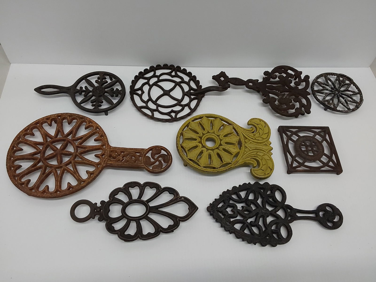 (9) cast iron trivets: (9) cast iron trivets
