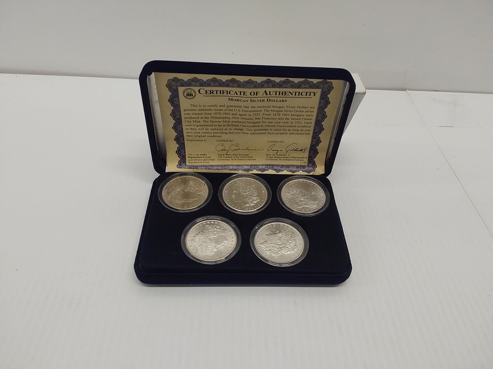 (5) Morgan silver dollars in case (1 of 2)
