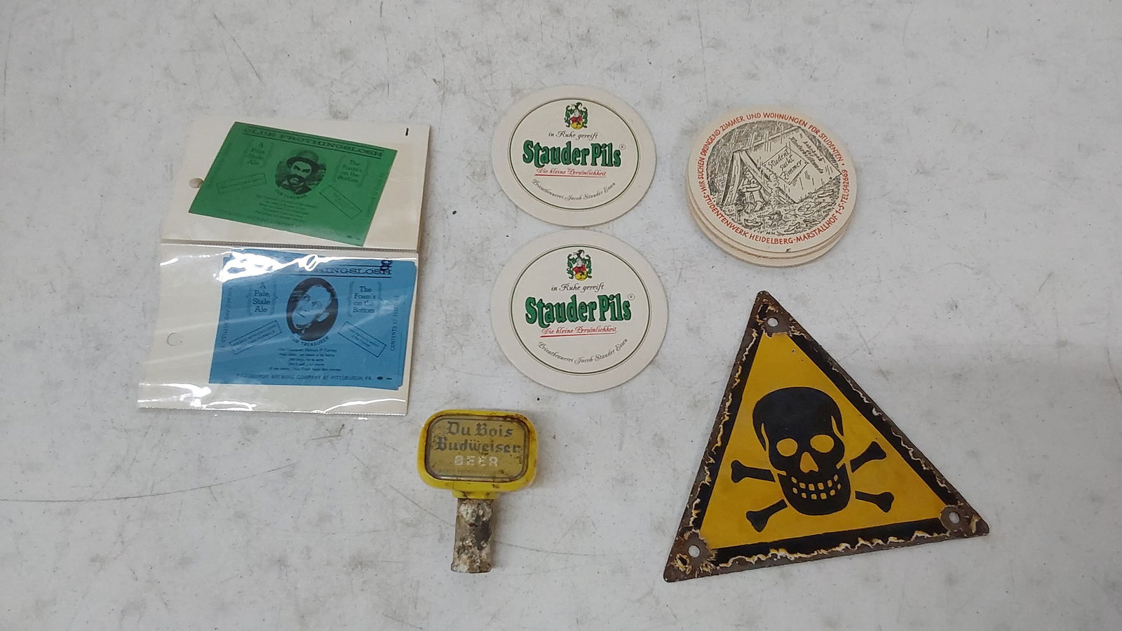 flat of miscellaneous collectibles: (33) 1970s Olde Frothing Slosh paper bottle labels, DuBois Budweiser tap handle, porcelain poison sign.