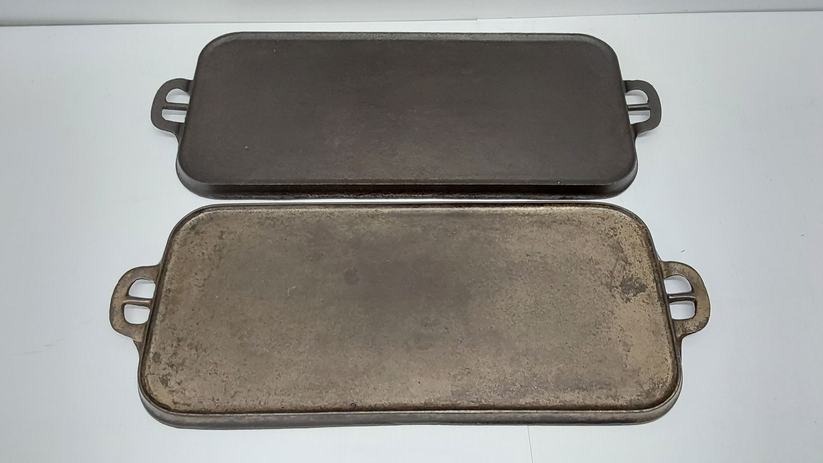 (2) cast iron griddles: (1) Wagner and (1) unmarked with pitting