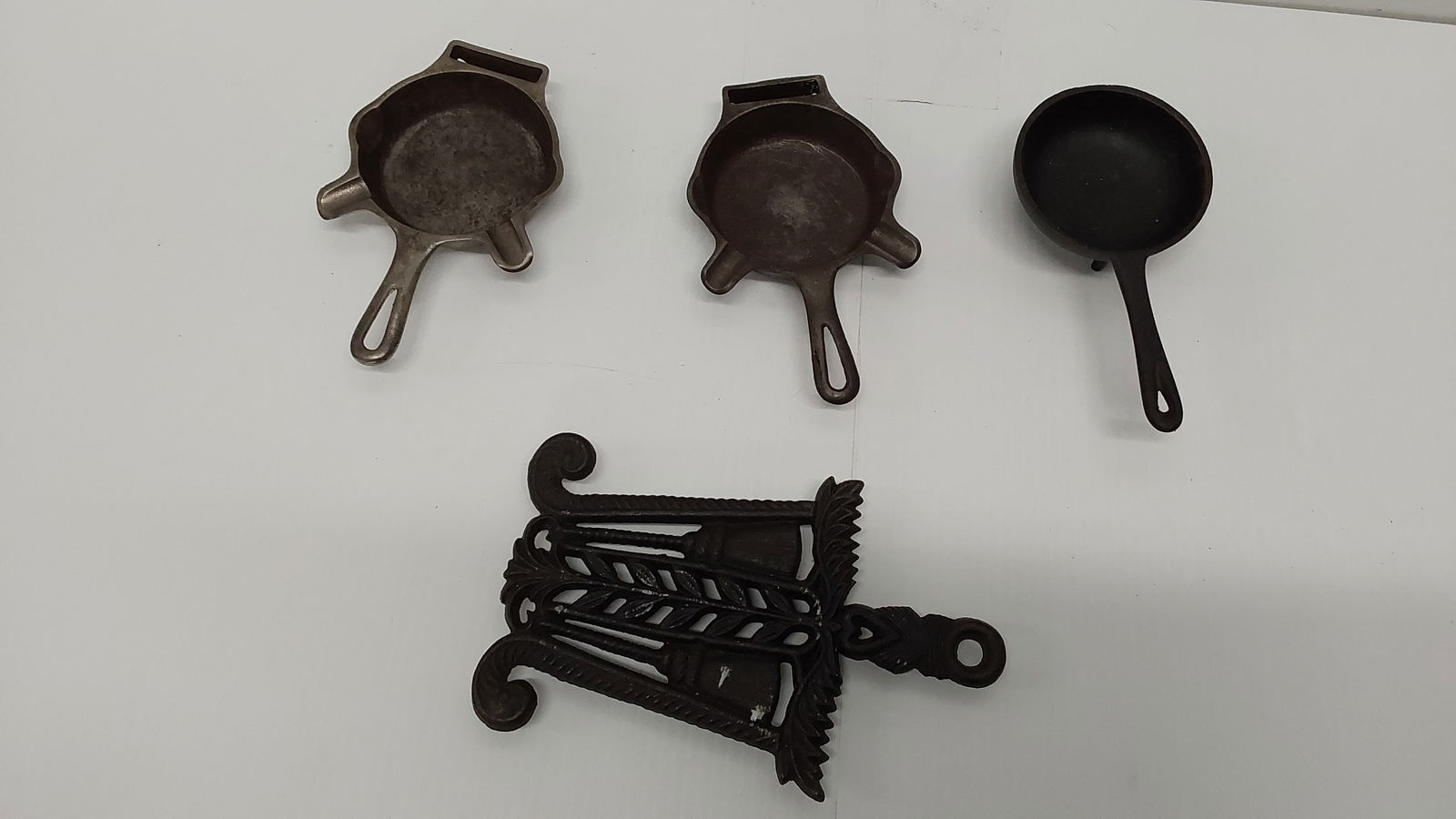 flat of (4) Griswold pieces: (3) ashtrays and (1) trivet