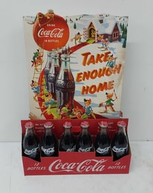 12-pack of Coca-Cola bottles w/cardboard sign