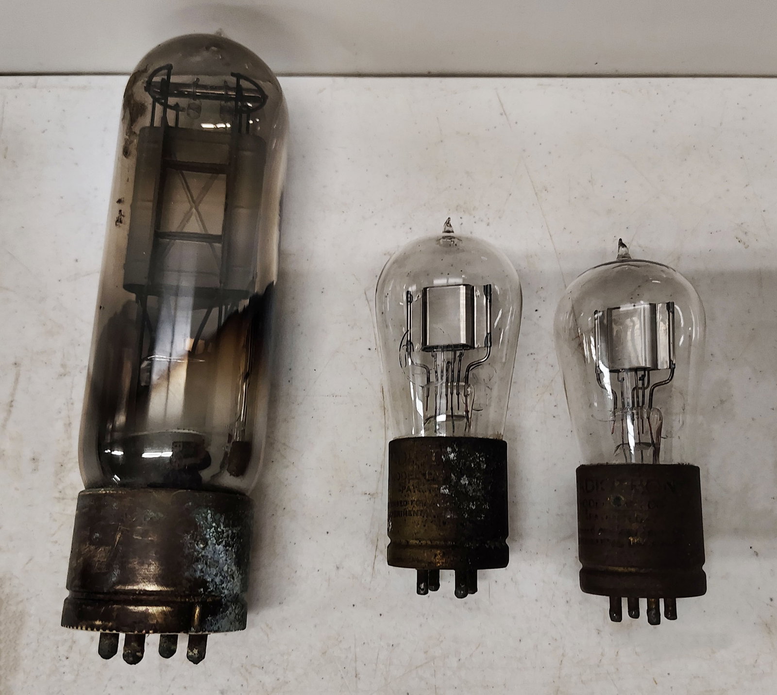 vacuum tubes: larger one unmarked 2 smaller ones marked but hard to make out the brand