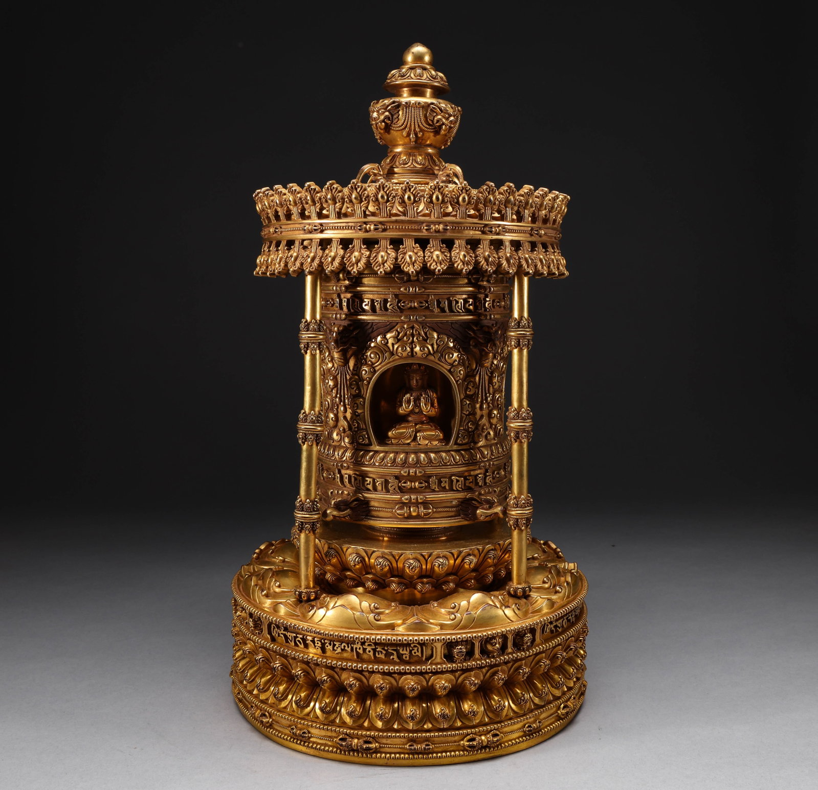 Qing Dynasty Copper Gilded Golden Bucket Buddha Statue: This golden bronze gilded Buddha niche statue is a cylindrical tower structure with a canopy style top decoration on the upper part. The entire body is decorated with lotus petals, rolled grass, and a