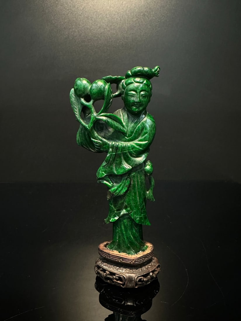 Qing Dynasty Jade Magu Offering Longevity: A jade figure carving ornament, made of green jade and stone, with a crown on the head, distinct clothing patterns, and holding flower branches. The overall shape has the charm of traditional Eastern 
