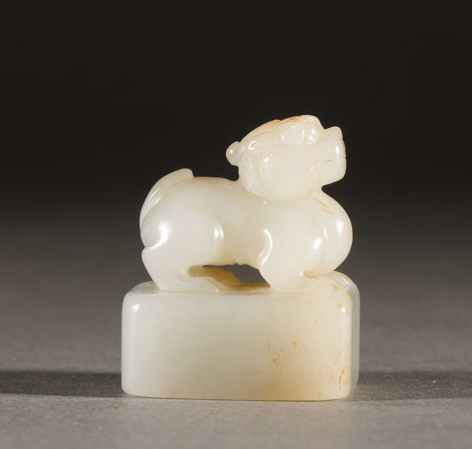A seal of Hotan Jade in Qing Dynasty: Hetian Baiyu Pixiu Ruishou Niu YuyinThe size is 3.2 cm in height and 3.5 cm in width, weighing 48g. The white jade texture is smooth and delicate, with a round carved reclining auspicious beast as the