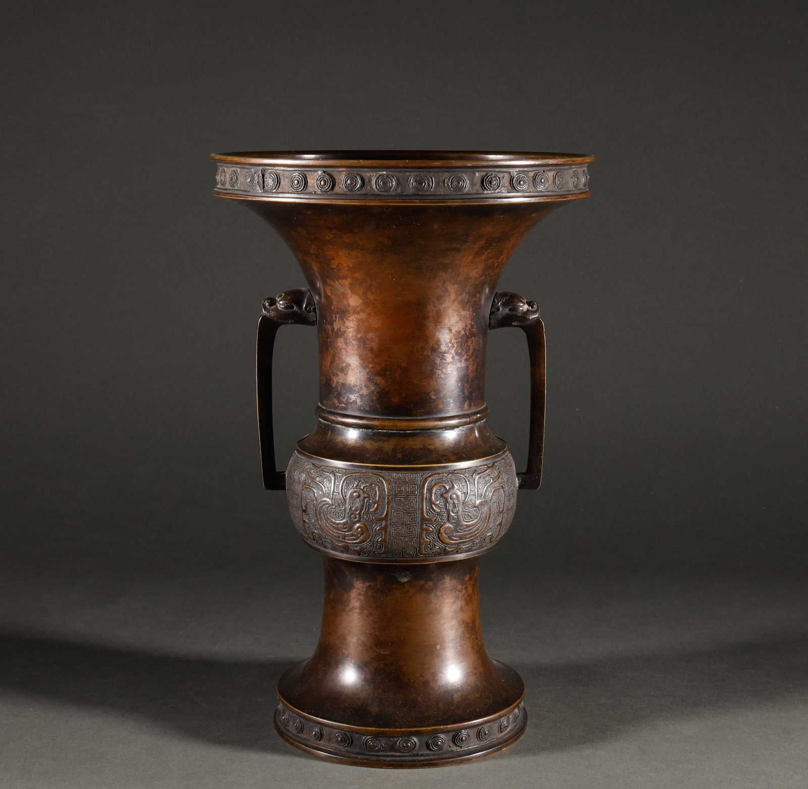 Returning to Qing Dynasty Copper Double Eared Bronze Zun: The antique animal ear phoenix patterned copper flower shaped pottery has a height of 29.5 to 19cm and a weight of 1618g. It is made of antique copper and features a beast head with two ears, mouth an