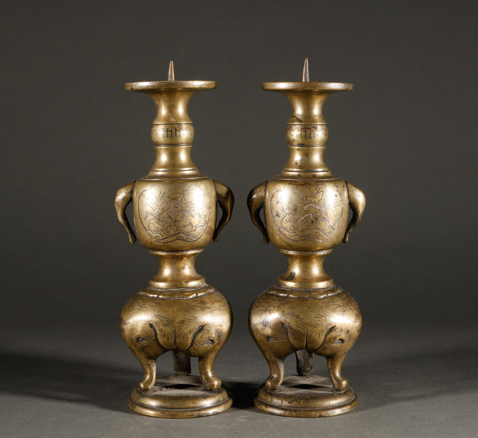 Reflux Qing Dynasty Copper Inlaid Silver Tripod Copper Candlestick Pair: The old collection of brass elephant ear flower and bird patterned candlesticks is paired, with a height of 25cm, a width of 8cm, and a total weight of 1606g. The object has a wax insertion structure,