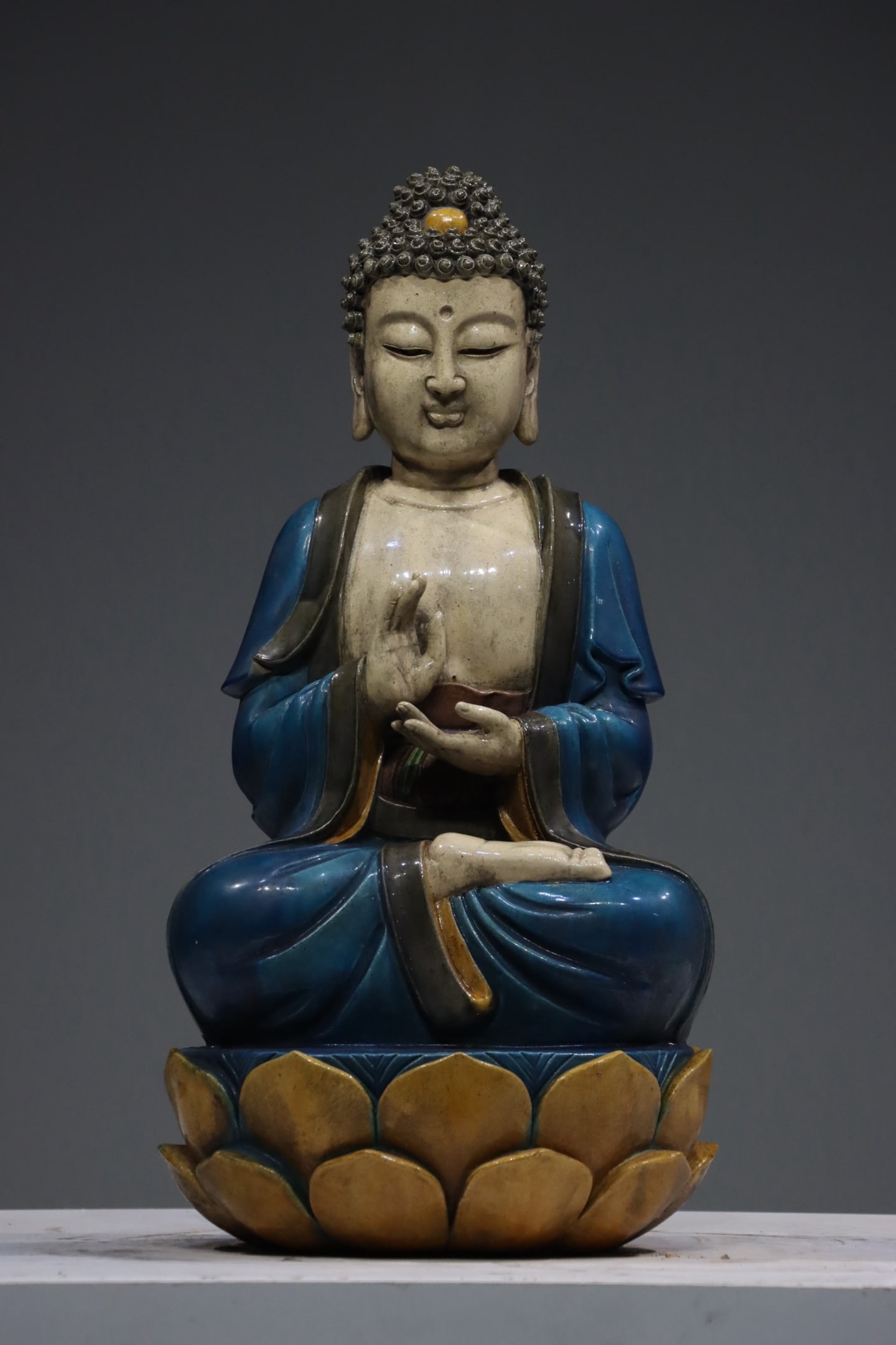 Ming Dynasty Three Colored Statue of Shakyamuni Buddha: The old Tibetan blue glazed lotus throne of Shakyamuni Buddha, standing 61cm high. The Buddha statue has a gentle and peaceful face, with a graceful and serene meditation posture. The jade blue robe h