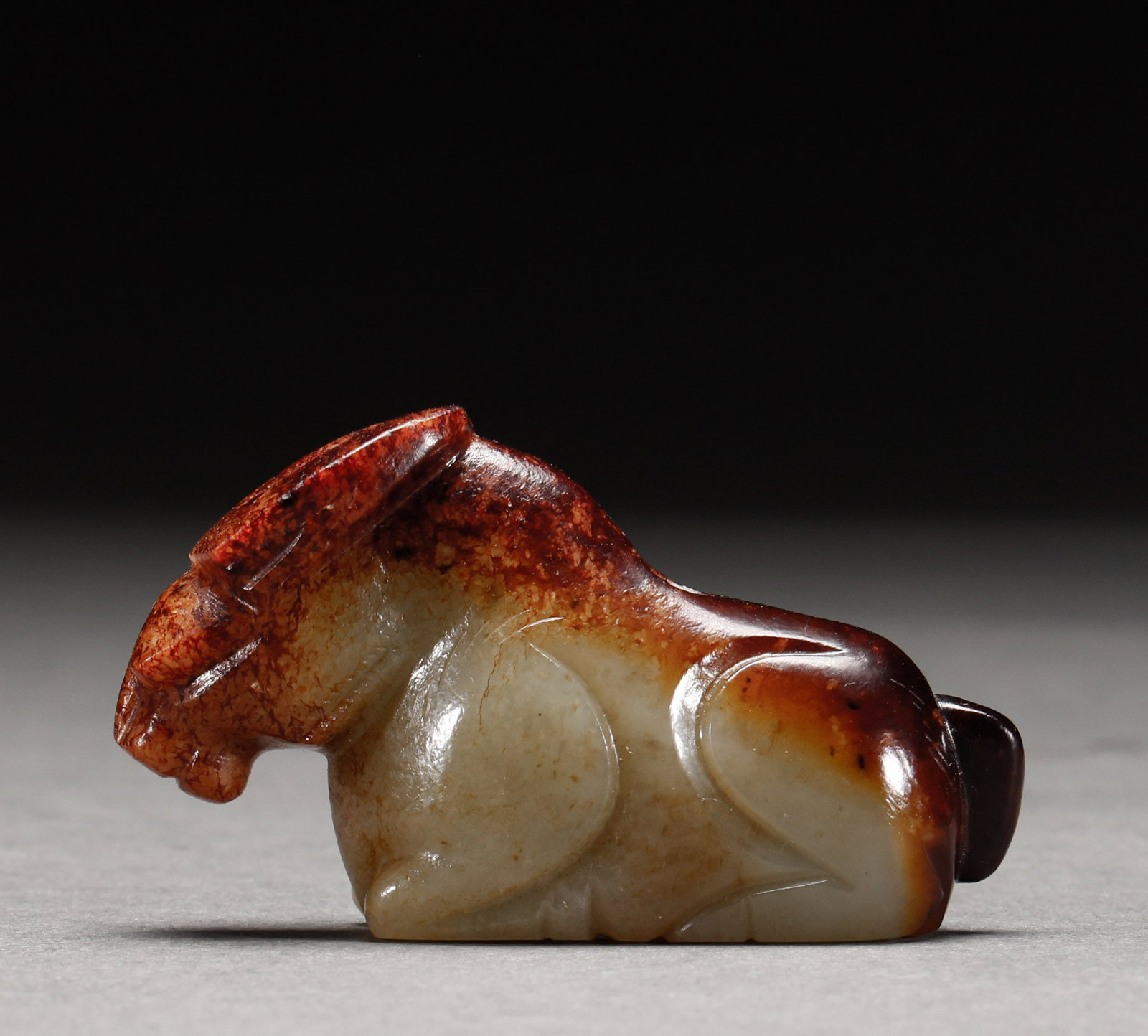 He Tian Yu Beast before the Ming Dynasty: Pre-Ming Hetian Jade Beast. Perfectly formed and full of distinctive charm, the piece stands 3.5 cm tall, is 6.2 cm wide, and weighs 65 g. Fine-grained and thickly patinated, complete in form and spir