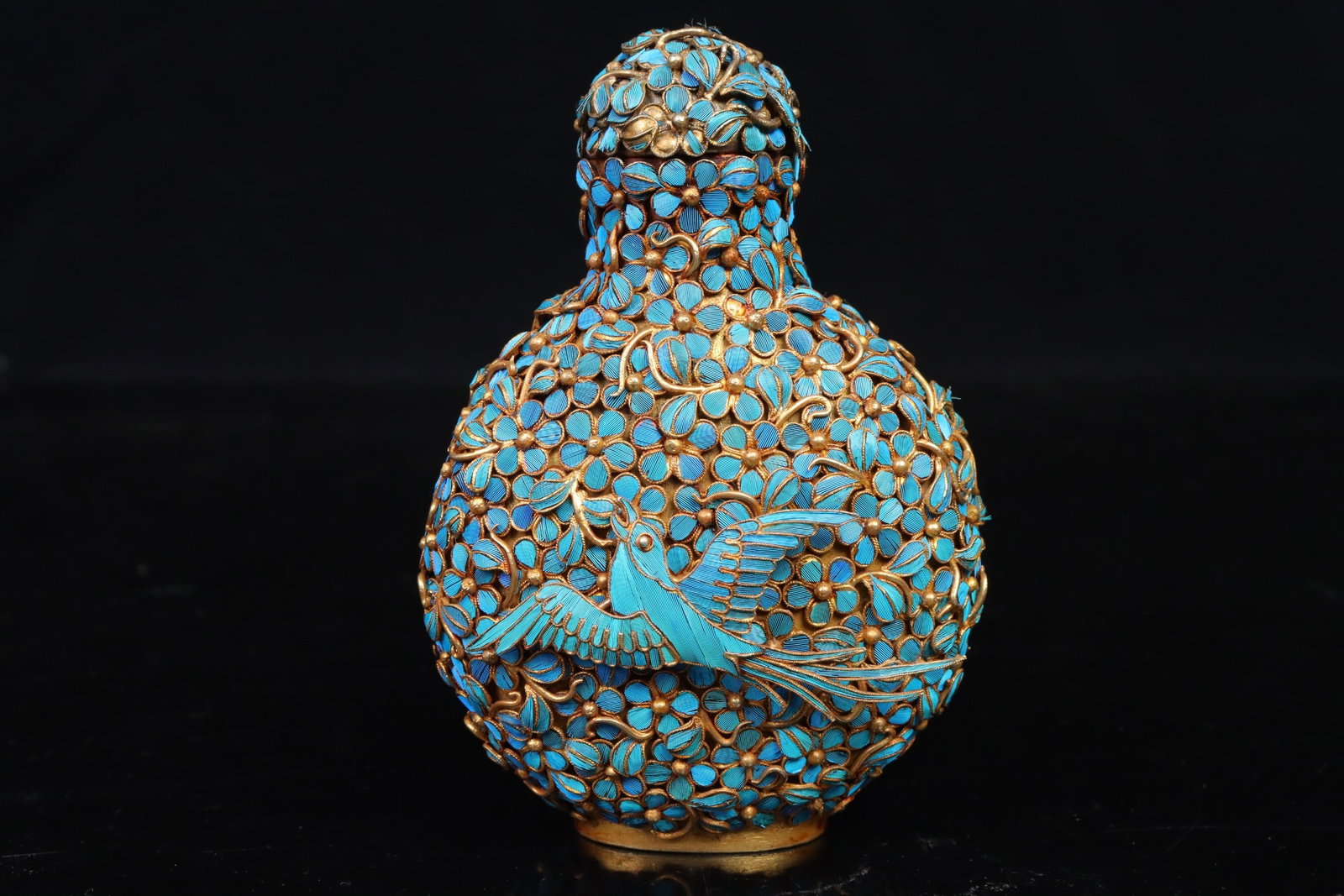 Qing Dynasty copper gilded point emerald snuff bottle: Qing-Dynasty Gilt-Bronze Snuff Bottle with Kingfisher Inlay. Well-proportioned in form and flowing in line, the piece stands 9 cm tall, is 6.5 cm wide, and weighs 116.6 g. The glaze is moist, the enam