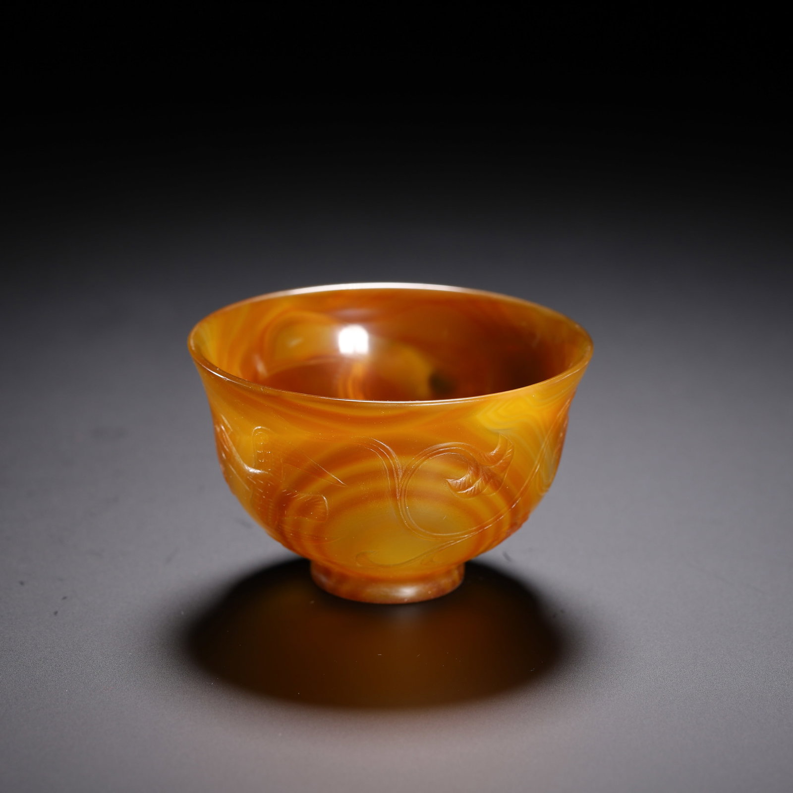 Qing Dynasty agate cup: Qing-Dynasty Agate Cup. Splendid and dignified, bearing an air of grandeur, the piece stands 4 cm tall, and is 6.5 cm wide. The body and glaze are lustrous, the colors pure, the decoration fine, showi