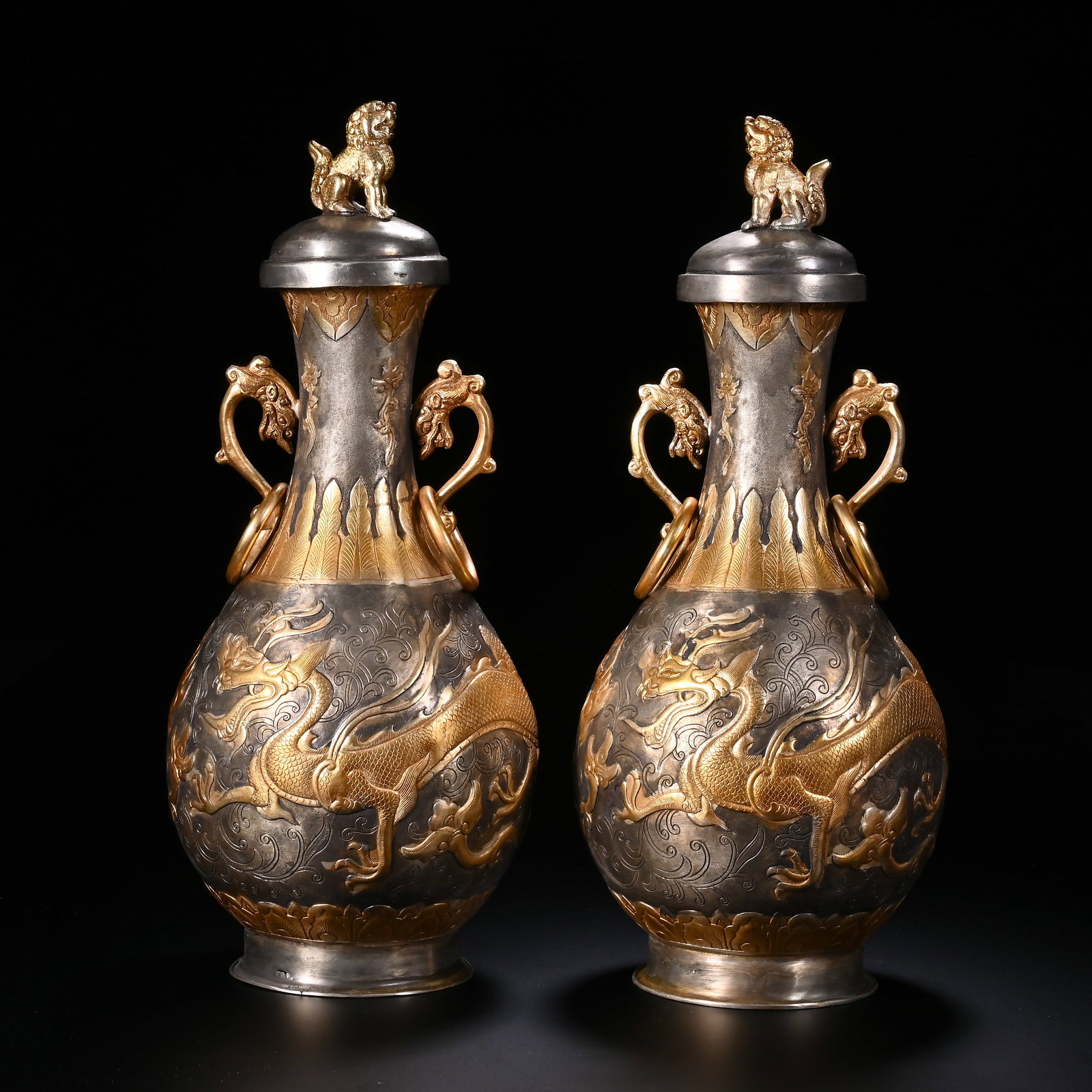 A pair of bronze gilded gold and silver dragon patterned vases from the Qing Dynasty: Qing-Dynasty Pair of Gilt-Bronze Vases with Silver Dragon Motifs. Meticulously worked with singular artistry, the piece stands 30 cm tall, and is 12.5 cm wide. The form is full, the glaze clear and el