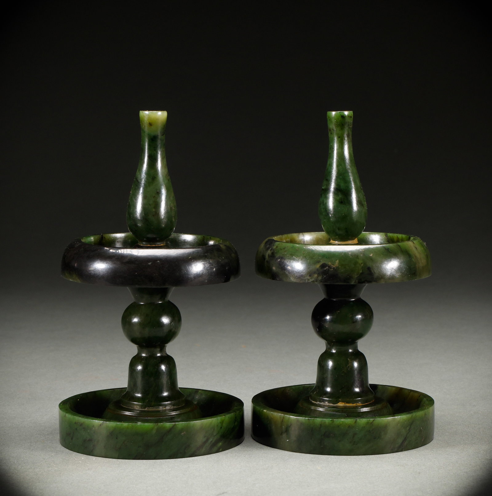 A pair of Hetian jade lampstands in the Qing Dynasty: Qing-Dynasty Pair of Hetian Jasper Lamp Stands. Meticulously worked with singular artistry, the piece stands 15.5 cm tall, is 8.8 cm wide, and weighs 1,008 g. The material is glossy, the carving incis